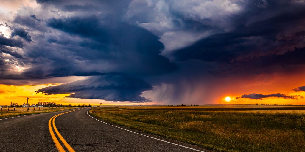 5DM42108 Empty highway with severe supercell thunderstorm in background with low-hanging, rotating wall cloud