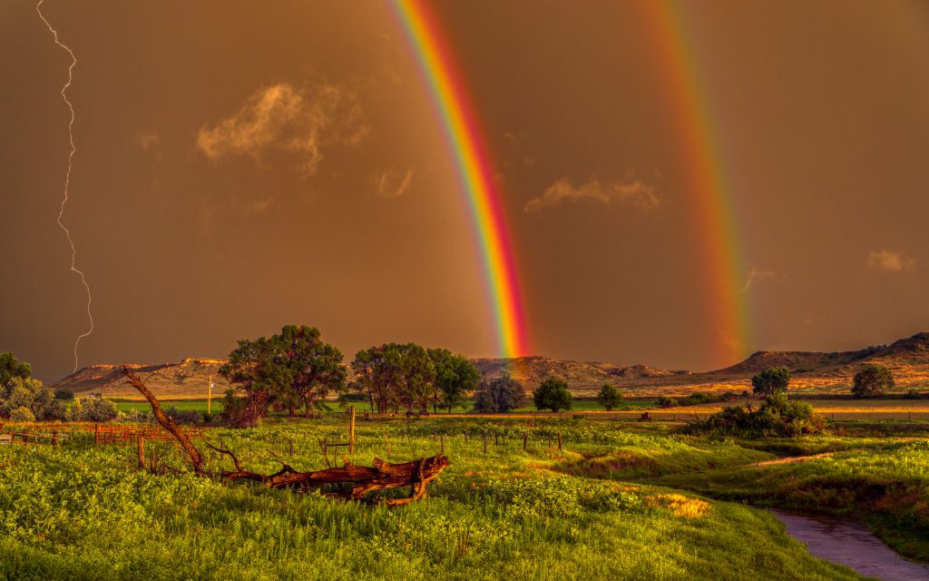 5DM48629 Photo of lightning striking plateau next to brilliant double rainbow with water rushing through creek in foreground